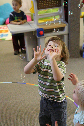 Everyone loves bubbles. Children playing with bubbles. Has nothing to do with the building location other than to entice you.